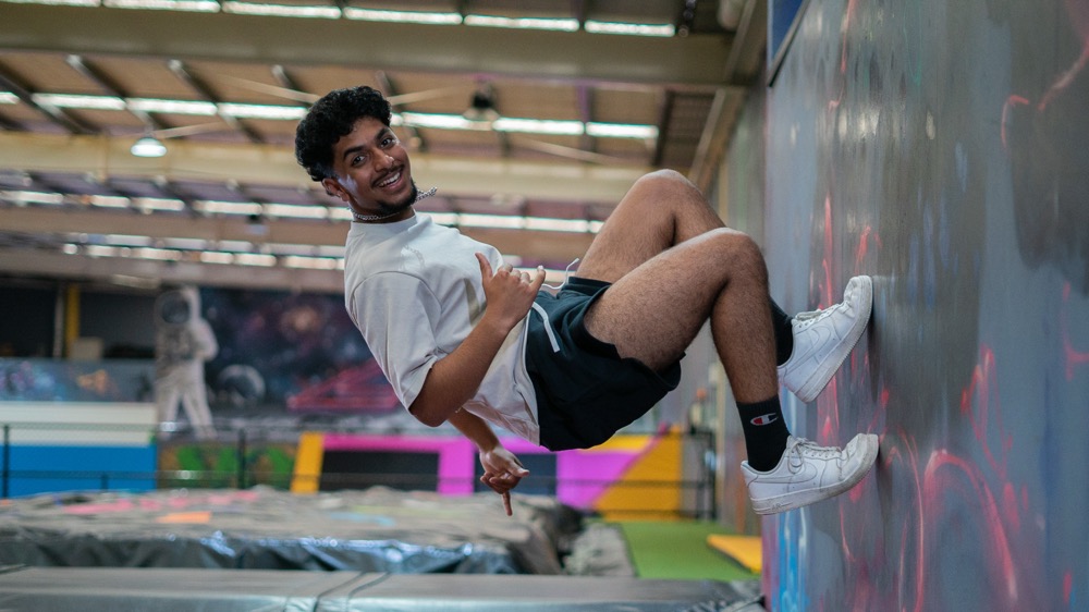 Participant wall-running above trampolines at Airborn Air Park