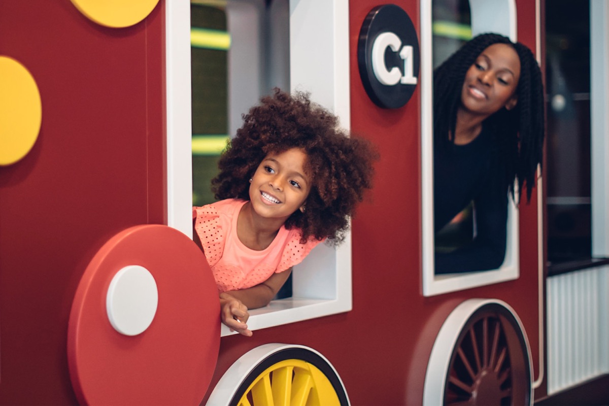 Child and carer playing in the Pauline Gandel Children's Gallery train exhibit